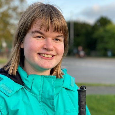 Girl in green coat smiles for the camera