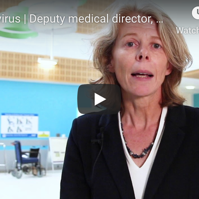 Sue Broster, deputy medical director is speaking to the camera, there is a hospital reception setting behind her.