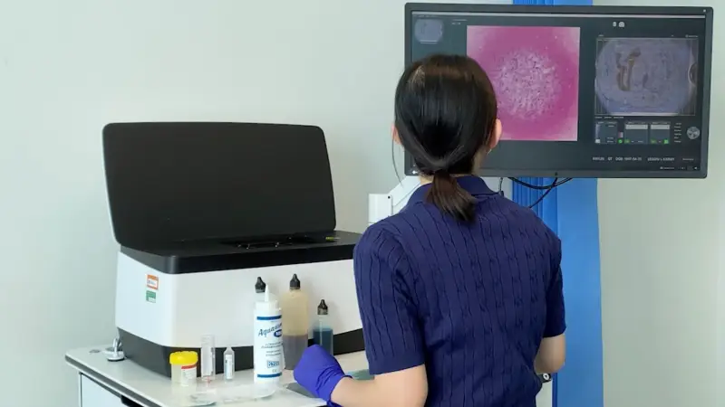 Pathologist technician using the confocal microscope at the one-stop clinic