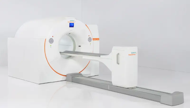The new total-body PET scanner a large white ring-shaped machine that patients will lie within during scans