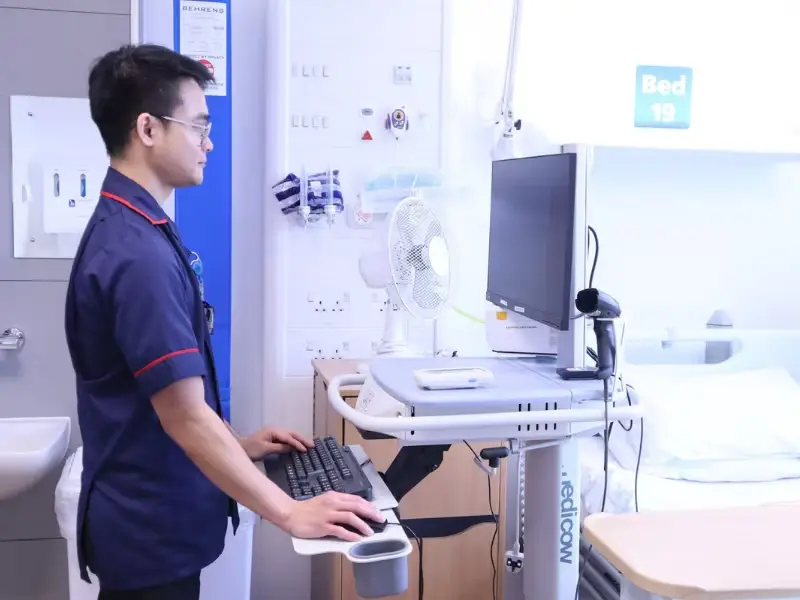 Nurse working at standing workstation in empty patient room in Movement Hub