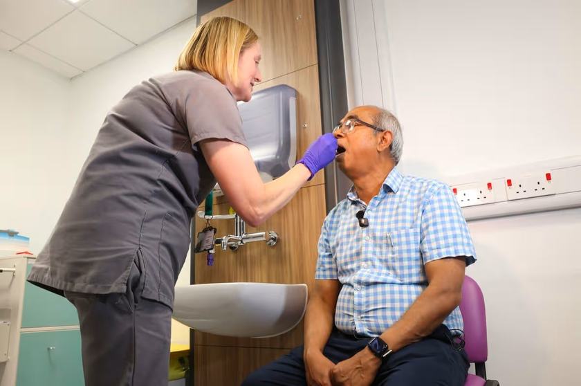 Advanced care practitioner Suzanne Hawkins swabs the mouth of patient Ashraf Ali at the new minor stroke clinic at the Queen’s Medical Centre in Nottingham.