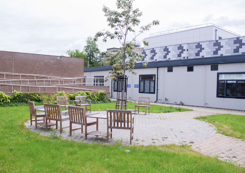 The garden area outside of T2 includes seating and plants.