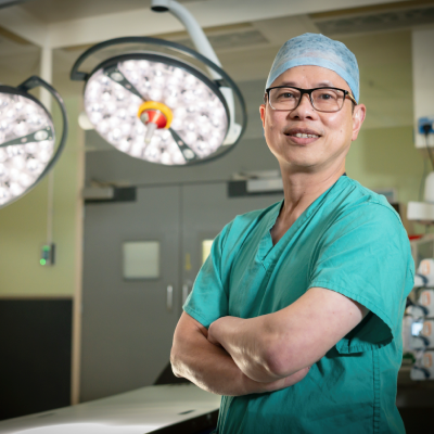 A doctor wearing theatre scrubs standing in front of theatre lights