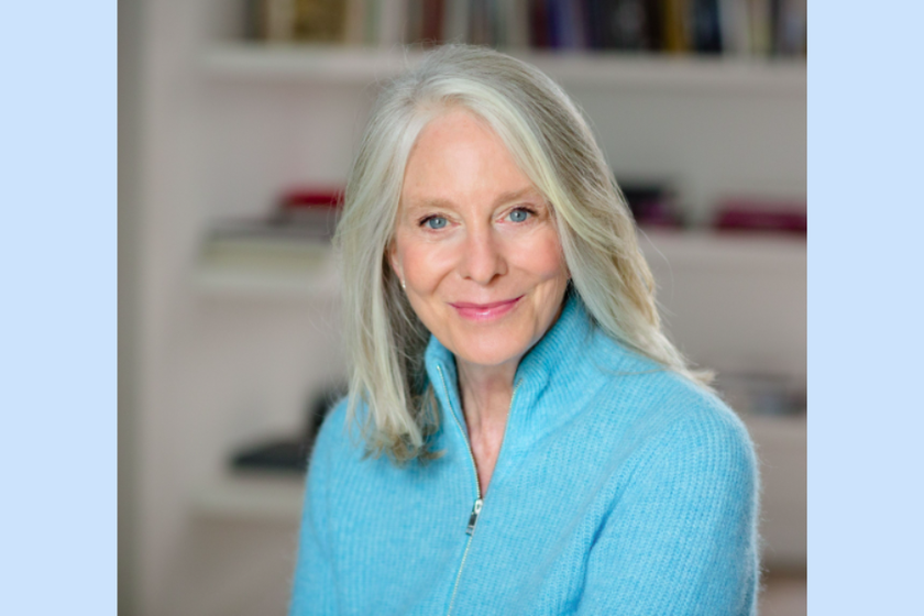 a woman with long grey hair and a turquoise jumper