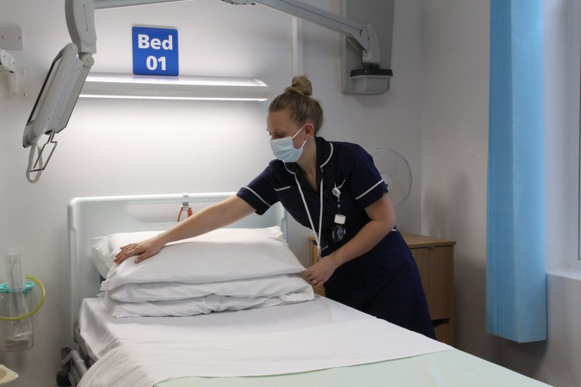 Nursing making bed in surge centre ward