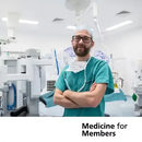 Grant Stewart standing in an operating theatre in scrubs. Text below reads 'Medicine for Members'