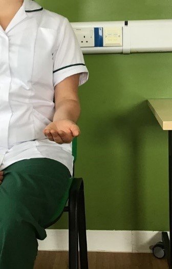 A person sat with their arm out in front of them with their palm turned upwards