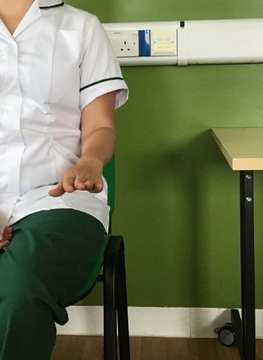 A person sat with their arm out in front of them with their palm turned downwards