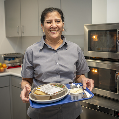 Savi Patel holding a tray with food for a patient on it