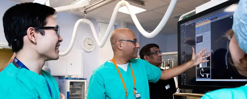 Team of doctors viewing a screen showing images of the body