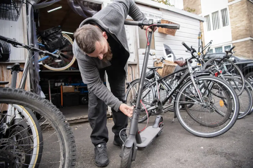 cycle hub colleague looks at electric scooter for repair