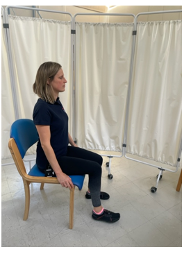 A woman sat on a chair with both feet on the ground