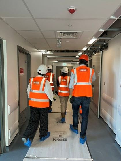 CCH Team walking through the Moorfields Eye Hospital, which is currently under construction- all are wearing PPE, hardhats and high vis vests. They are walking away from the camera.