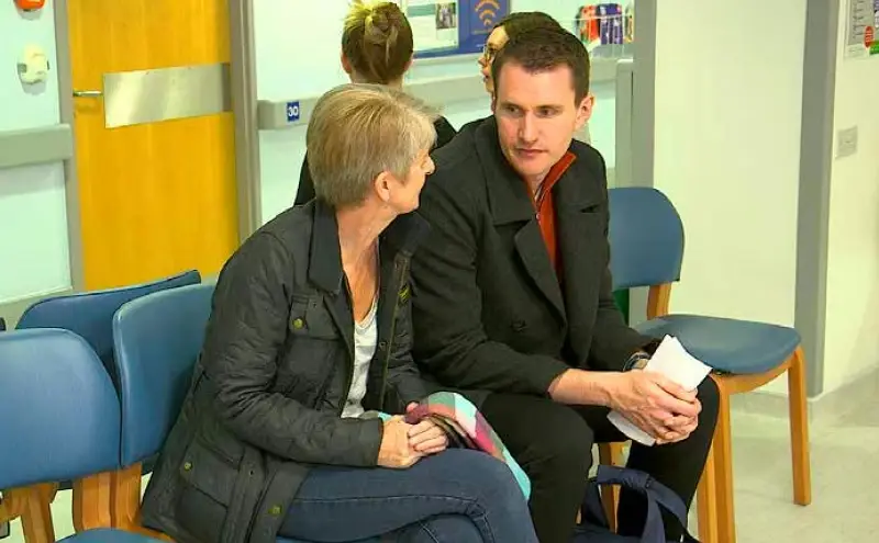A patient and loved one sat in a hospital waiting area.