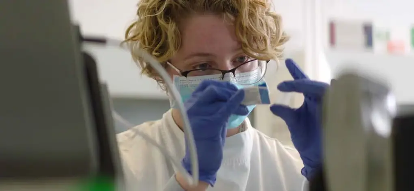 Researcher looking at sample in laboratory