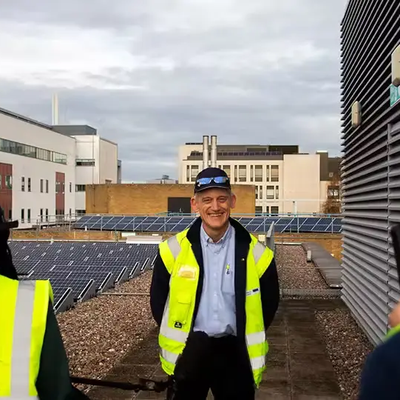 Richard Hales being interviewed by BBC Look East in front of solar panels on the CUH campus