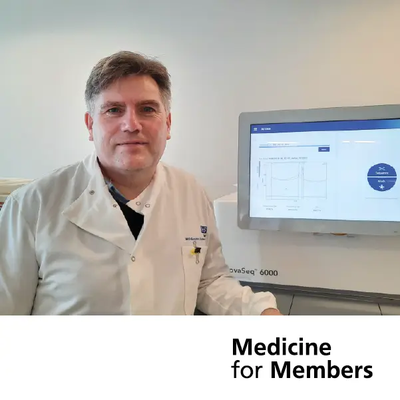 Patrick Tarpey in a white lab coat standing by a screen. Text reads 'Medicine for Members'